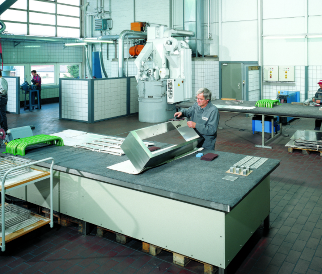 Mitarbeiter beim Schleifen und Polieren von Metallbauteilen
