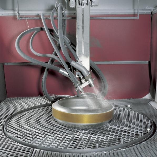 View into the blasting cabin of an automatic glass-ball machine; stainless-steel tank on turntable