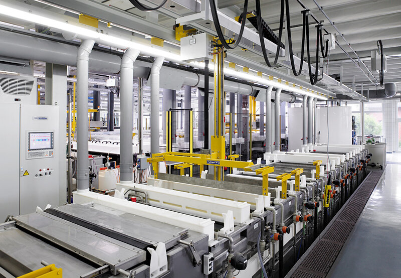 Reihe von industriellen Wannen und Maschinen zur Materialverarbeitung in einer hellen, sauberen Industriehalle
