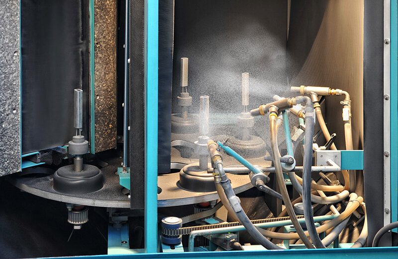Industrielle Maschine mit mehreren Schläuchen und Sprühdüsen, die feinen Nebel versprühen