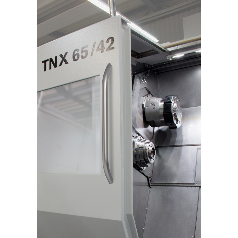 Geöffnete Industriemaschine TNX 65/42 mit gebogenem Edelstahlgriff am Türrahmen